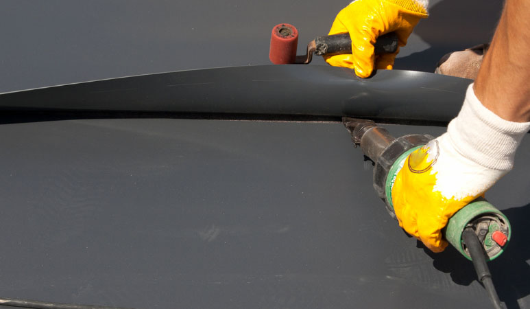 A man applying rooftop coating