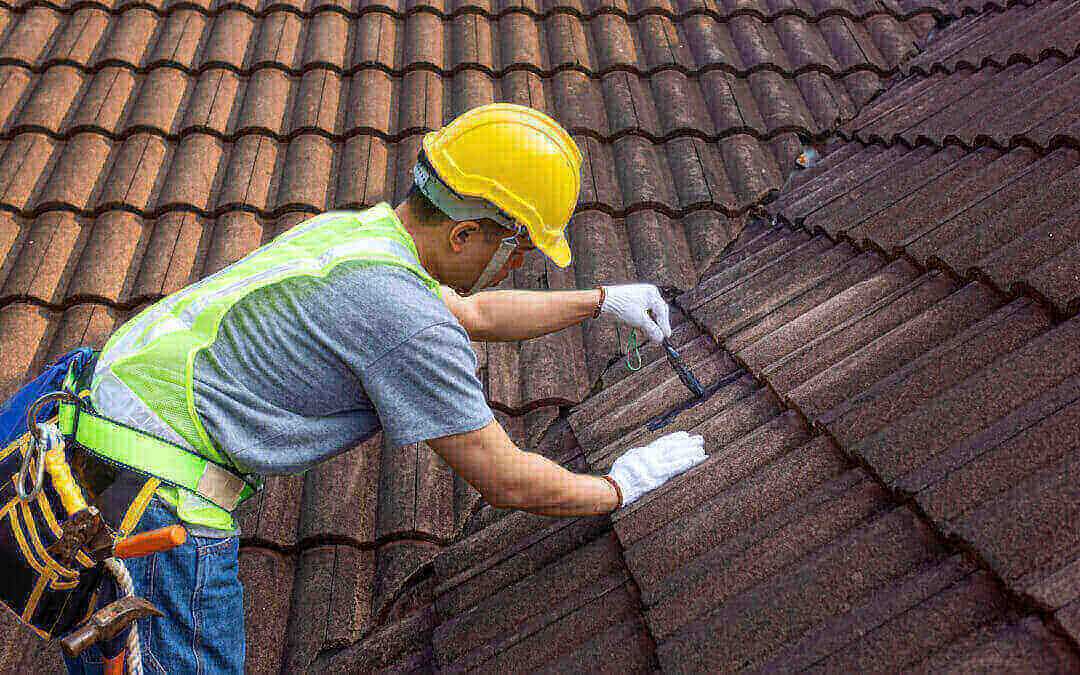 Worker man maintaining to fix crack of the old tile roof.
