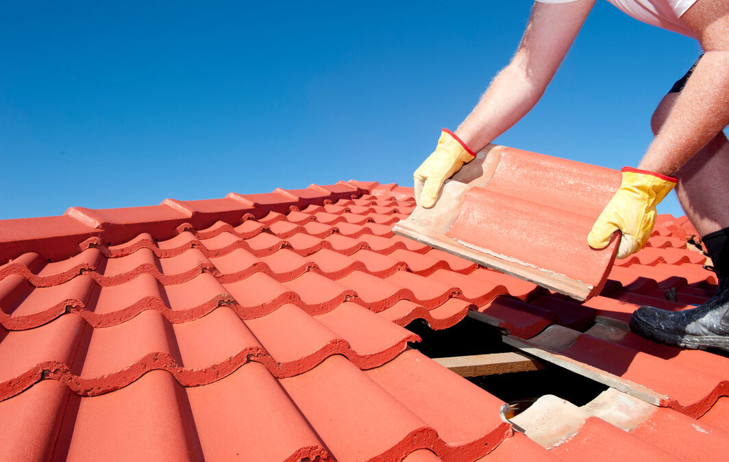 Construction worker tile roofing replacement