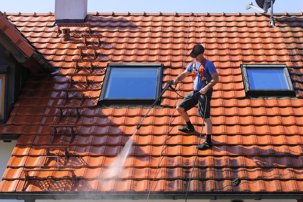 roof cleaning expert cleaning a roof with pressure water